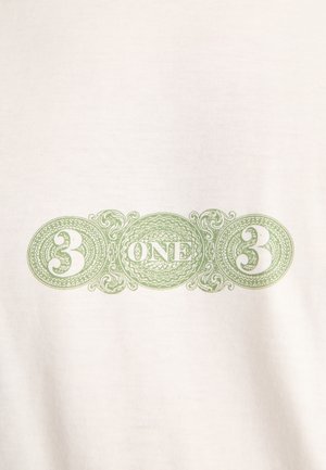 Grünes, verziertes Design mit der Zahl 3 auf beiden Seiten und dem Wort EINS in der Mitte auf einem weißen Stoffhintergrund.