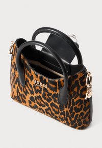 Tasje met luipaardprint, afgewerkt met zwarte leren accenten, twee handvatten aan de bovenkant en een gouden logo. Bevat een magnetische flap en glanzende hardwaredetails.