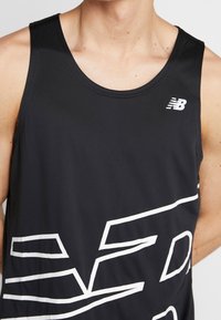 Czarny sportowy top na ramiączkach wykonany z gładkiego, lekkiego materiału. Posiada biały wzór graficzny oraz małe białe logo na piersi.