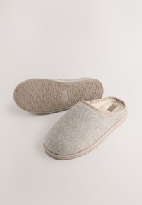 Sivé vlnené papuče s mäkkým vnútrom, zaoblenou špičkou a svetlou gumovou podrážkou so zvlneným vzorom. Zvýraznené béžovým lemovaním.