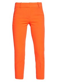 Pantalon sur mesure orange vif à coupe slim, texture lisse, avec passants de ceinture, poches avant et un pli marqué à l'avant.