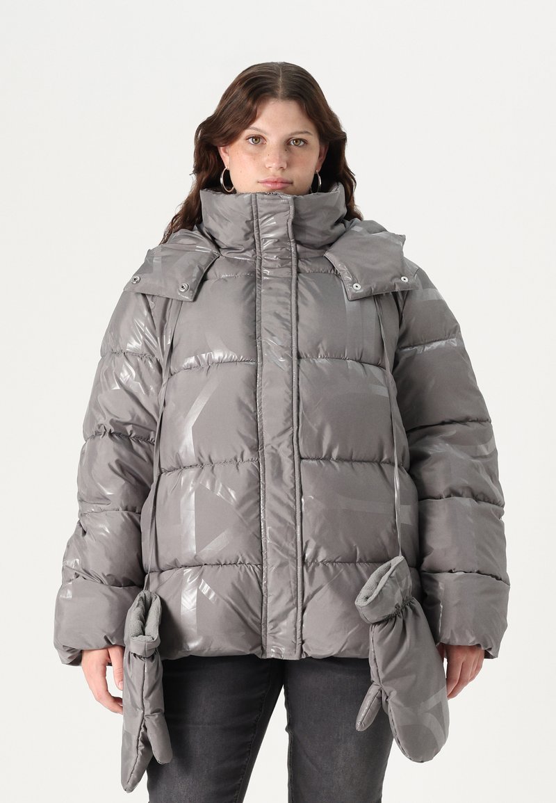 Sivi pufasti kaput s visokim ovratnikom, sjajnom završnom obradom, oversized siluetom i pripadajućim rukavicama pričvršćenim na struku.