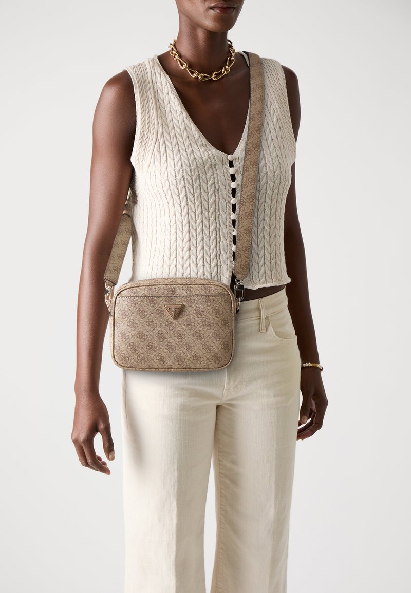 Beige patterned crossbody bag with a rectangular shape, leather material, front logo detail, and an adjustable strap.