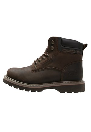 Botín de cuero marrón con suela rugged, punta redonda, ojales de metal y un cuello acolchado. Presenta una marca en el lateral.