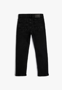 Pantalones vaqueros de mezclilla negra con un diseño ajustado, estilo de cinco bolsillos y una pequeña etiqueta de la marca en la cintura trasera.