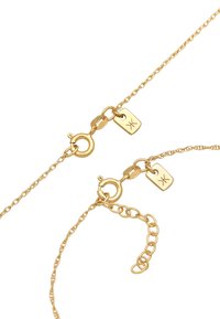 Gul kædedesign med en rund lobster clasp, forlængerkæde og et gravert mærke med et lille symbol. Glat tekstur og delikate led.