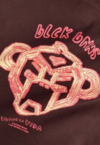 Gestileerde roze en crèmekleurige geometrische jaguarkop met de tekst "Black Boys" erboven en "Viva La Vida Transform The Generation" eronder op donkere stof.