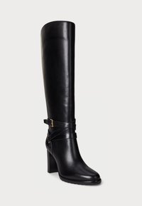 Botte noire en cuir, montant jusqu'au genou, avec un bout carré, un talon épais et un détail de sangle croisée orné d'une boucle en or. Texture lisse.