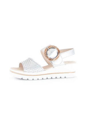 Silver woven strap sandals with a circular wooden accent, a cushioned white sole, and smooth leather straps. Adjustable back strap.