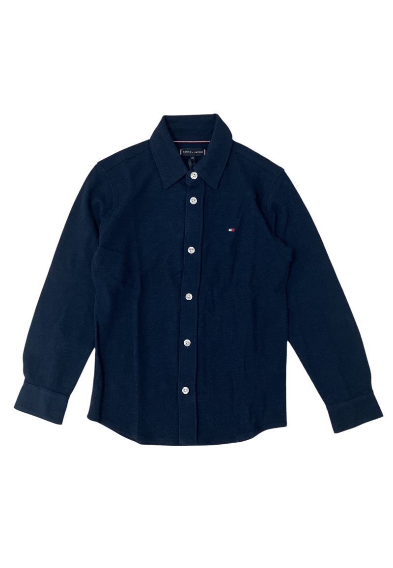 Camicia blu navy con bottoni in morbido tessuto, caratterizzata da un colletto classico, maniche lunghe e chiusure a bottone bianche. Piccolo logo applicato sul petto.