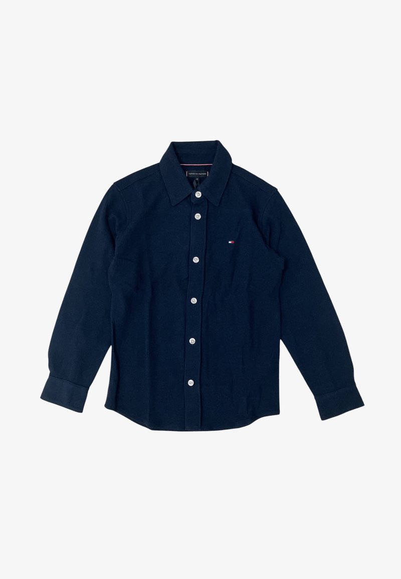 Camicia blu navy con bottoni in morbido tessuto, caratterizzata da un colletto classico, maniche lunghe e chiusure a bottone bianche. Piccolo logo applicato sul petto.