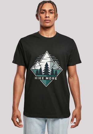 Black cotton t-shirt featuring a graphic design with mountains, trees, and the text "HIKE MORE" in white and green tones.