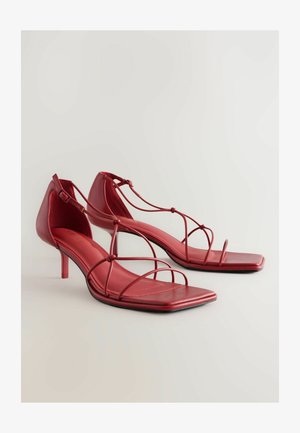 Punane nahast kõrge kontsaga sandaalid ruudukujuliste varvastega, mitme õhukese rihmaga jala üle ja reguleeritava pahkluu pannaliga. Tekstuuriga sisetald.