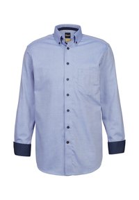 Camicia button-up azzurro chiaro con un design a motivi. Presenta bottoni neri e polsini a motivi blu scuro a contrasto. Una tasca sul petto.