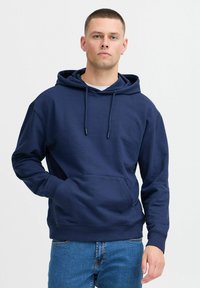 Navy blue pullover hoodie made of soft fabric, featuring a kangaroo pocket, drawstring hood, and ribbed cuffs and hem.