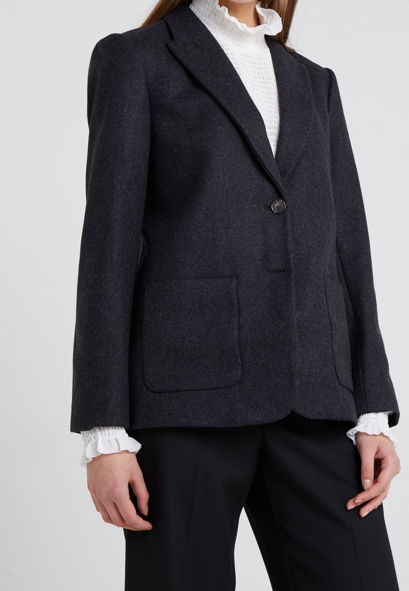 Blazer grigio carbone realizzato in un tessuto testurizzato, dotato di chiusura con un bottone singolo, due grandi tasche frontali e revers a punta.