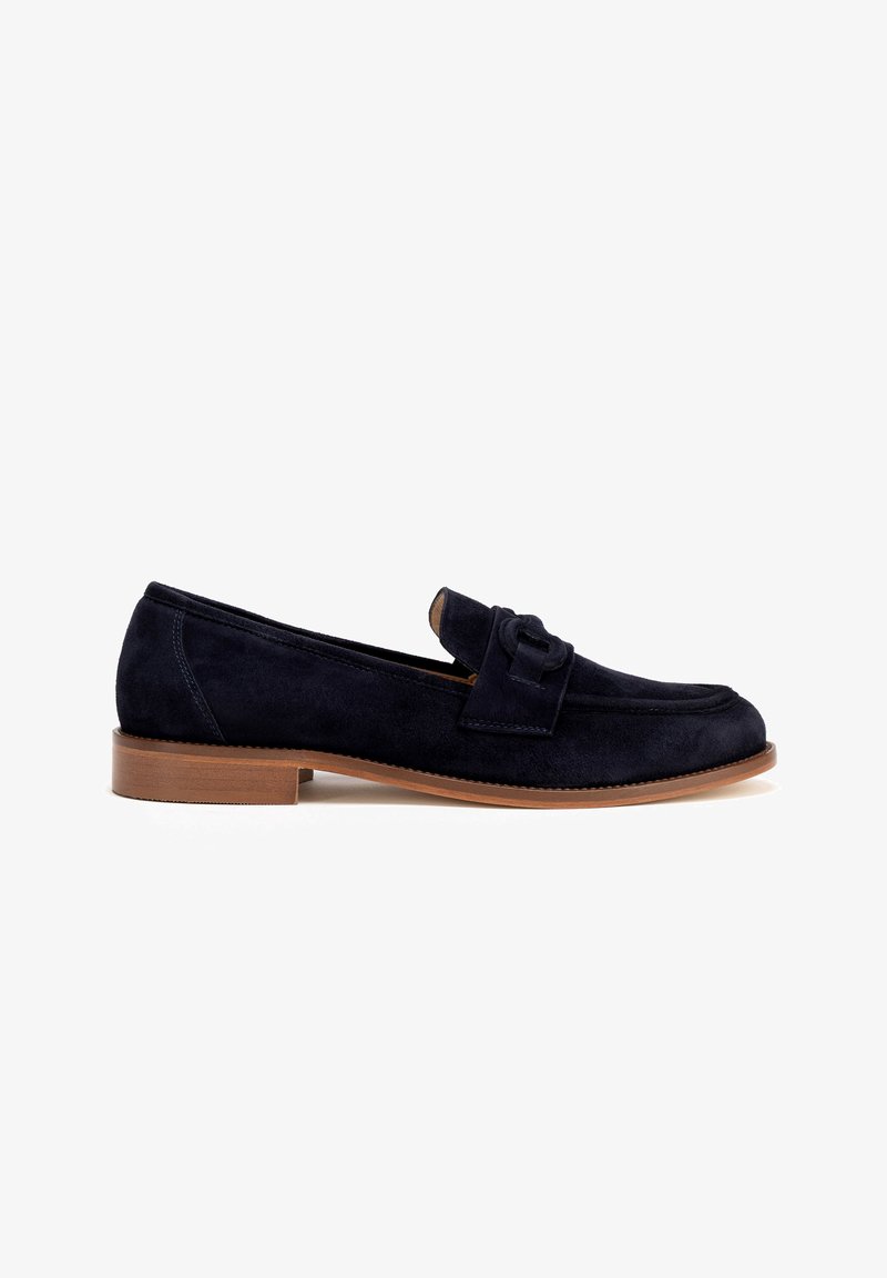 Mocassini in suede blu navy con sole piatta marrone, caratterizzati da un accento legato sulla parte anteriore e un design della punta arrotondato.
