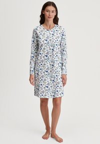 Vestito da notte a maniche lunghe realizzato in tessuto leggero, con uno sfondo bianco e motivi floreali colorati in blu, verde e viola.