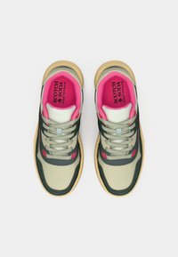 Zwei Sneaker mit einem Obermaterial aus hellgrünem und dunkelgrünem Stoff, pinkem Innenfutter und beiger Gummisohle. Merkmale sind Perforationen und Schnürsenkel.