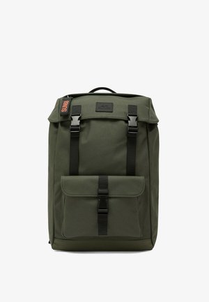 Zaino verde scuro con patta frontale e tasca chiuse da fibbie di plastica nere, maniglia per il trasporto sulla parte superiore e una piccola etichetta SUN68 sul lato.