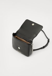 Svart läder crossbody-väska med magnetknäppning, silverkedjeaccent och brunt innerfoder. Har guldbranding på framsidan.