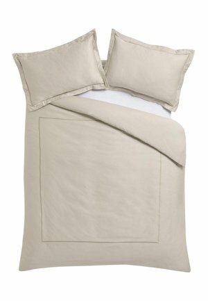 Beiger Bettbezug und zwei passende Kissenbezüge auf einem ordentlich gemachten Bett, bei dem eine Ecke der Bettdecke leicht zurückgefaltet ist.