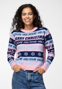 Pull en laine avec des rayures rose clair, marine et bleues comportant le texte "JOYEUX NOËL", des flocons de neige, et des poignets et un ourlet côtelés.