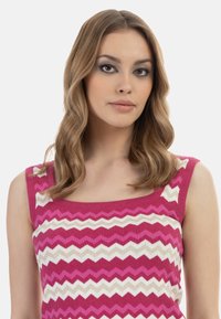 Top senza maniche con motivi a zigzag in rosa, bianco e oro; tessuto lavorato a maglia; scollatura quadrata e texture morbida.