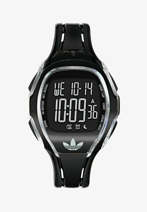 Skaitmeninis laikrodis su juodos gumos dirželiu ir aiškiomis plastikinėmis detalėmis. Turi juodą stačiakampio formos ciferblatą su baltu LCD ekranu ir „Adidas“ logotipu.