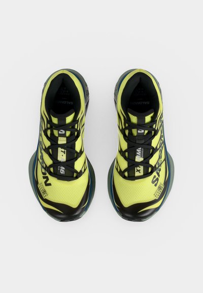 Φωτεινά κίτρινα και μαύρα παπούτσια τρεξίματος Salomon, άποψη από πάνω, σχεδιασμός με κορδόνια και διακοσμητικές λεπτομέρειες σε αναπνεύσιμη επιφάνεια από διχτυωτό υλικό.