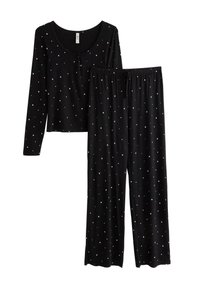 Sorte pyjamasæt med en langærmet top og matchende bukser. Begge dele har et stjernemønster i hvid, lavet af blødt stof.
