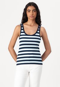 Tume- ja helesinise triibulise ribidega tank top, millel on laiad õlavarrerihmad ja ümar kaelus, kombineerituna valgete pükstega. Sile tekstuur.