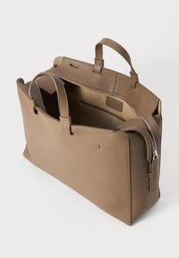 Bolsa tote de cuero marrón con cierre de cremallera, dos asas y un diseño minimalista. El interior cuenta con un bolsillo y una textura suave.