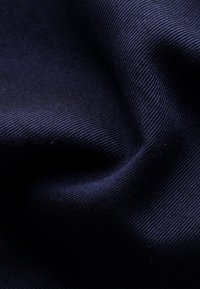 Tmavě modrá tkanina s jemným žebrovaným vzorem, hladkým povrchem a jemným leskem, který zvýrazňuje její tkaný vzor a hloubku.