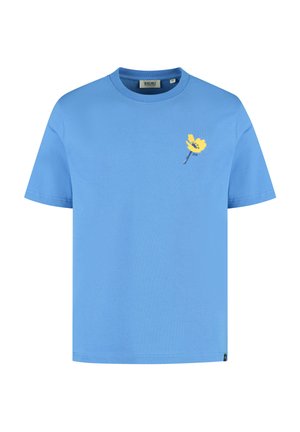 T-shirt a maniche corte con scollo rotondo in cotone azzurro chiaro. Presenta un design di fiore giallo sul lato sinistro del petto. Etichetta visibile sul colletto.