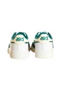 Zapatillas blancas con acentos verdes. Las características incluyen una suela blanca texturizada, un collar acolchado y un logotipo prominente de ASICS en el talón.
