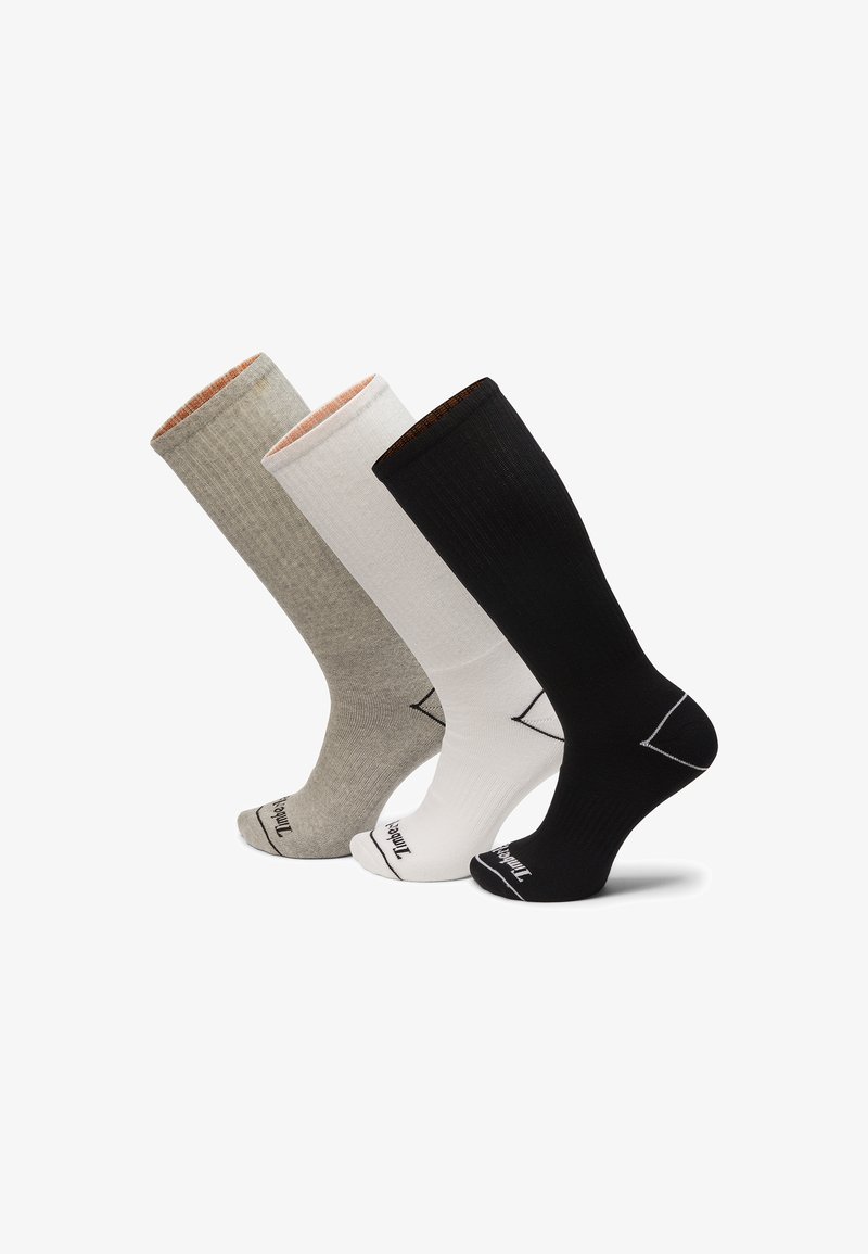 Trois paires de chaussettes montantes en gris, blanc et noir. Chacune présente une texture côtelée et des bordures de couleur contrastante.