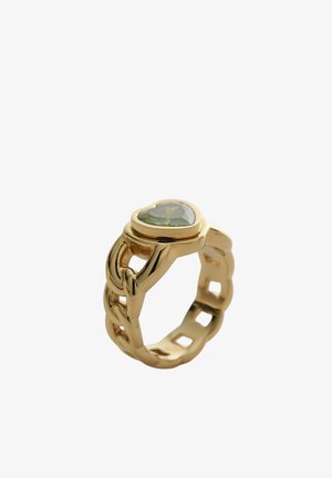 Bague en chaîne dorée ornée d'une pierre précieuse verte en forme de cœur, photographiée sur un fond blanc.