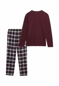 Maglione a maniche lunghe color bordeaux abbinato a pantaloni del pigiama a quadri con quadrati rossi, blu navy e bianchi. Materiale in cotone morbido e traspirante.