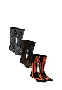 Quatre paires de chaussettes : noires avec un motif abstrait blanc, noires avec des accents marron, et noires avec un design en flammes orange, toutes tricotées.