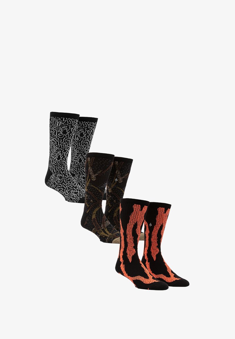 Four pairs of socks: black with white abstract pattern, black with brown accents, and black with orange flame-like design, all knitted.