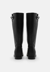 Bottes en cuir noir jusqu'aux genoux avec un design élégant, un talon plat et un détail de boucle décoratif sur le côté. Texture lisse et finition sans couture.