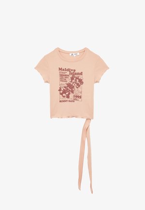 Ferskenfarvet cropped t-shirt lavet af blødt materiale, med et blomsterprint i mørkerød og en knyttet kantdetalje.
