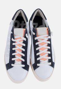 Baskets en cuir blanc avec des accents en daim marine et des détails perforés. Langue en mesh orange, lacets plats blancs et semelle en caoutchouc.