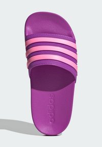 Fioletowa klapka na stopę z trzema różowymi poziomymi paskami, teksturowaną cholewką i wytłoczonym logo na wkładce. Płaski kształt, wykonana z gumy.
