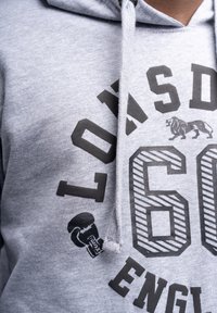 Hoodie in cotone grigio con una grande grafica nera stampata con il numero "60", un emblema di leone e dettagli di guantoni da boxe sul davanti.