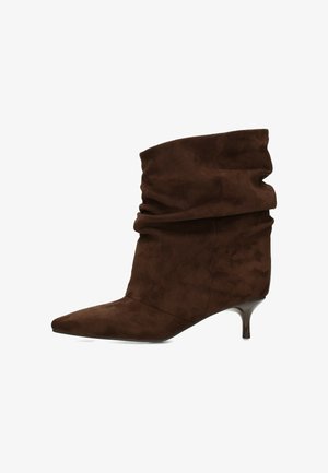 Brauner Wildleder-Stiefelette mit spitz zulaufender Spitze, legerem Schaft und niedrigem Kittenabsatz.