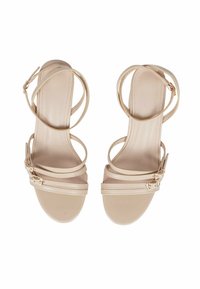 Sandali con tacco alto beige con più cinturini sottili. Texture in pelle liscia. Dettaglio della fibbia sul cinturino alla caviglia. Design open-toe.