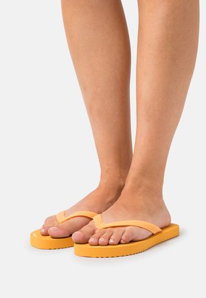 Yellow flip-flops with a thick, textured sole and a V-shaped strap. The rubber material is smooth, with a slight grip pattern on the sole.