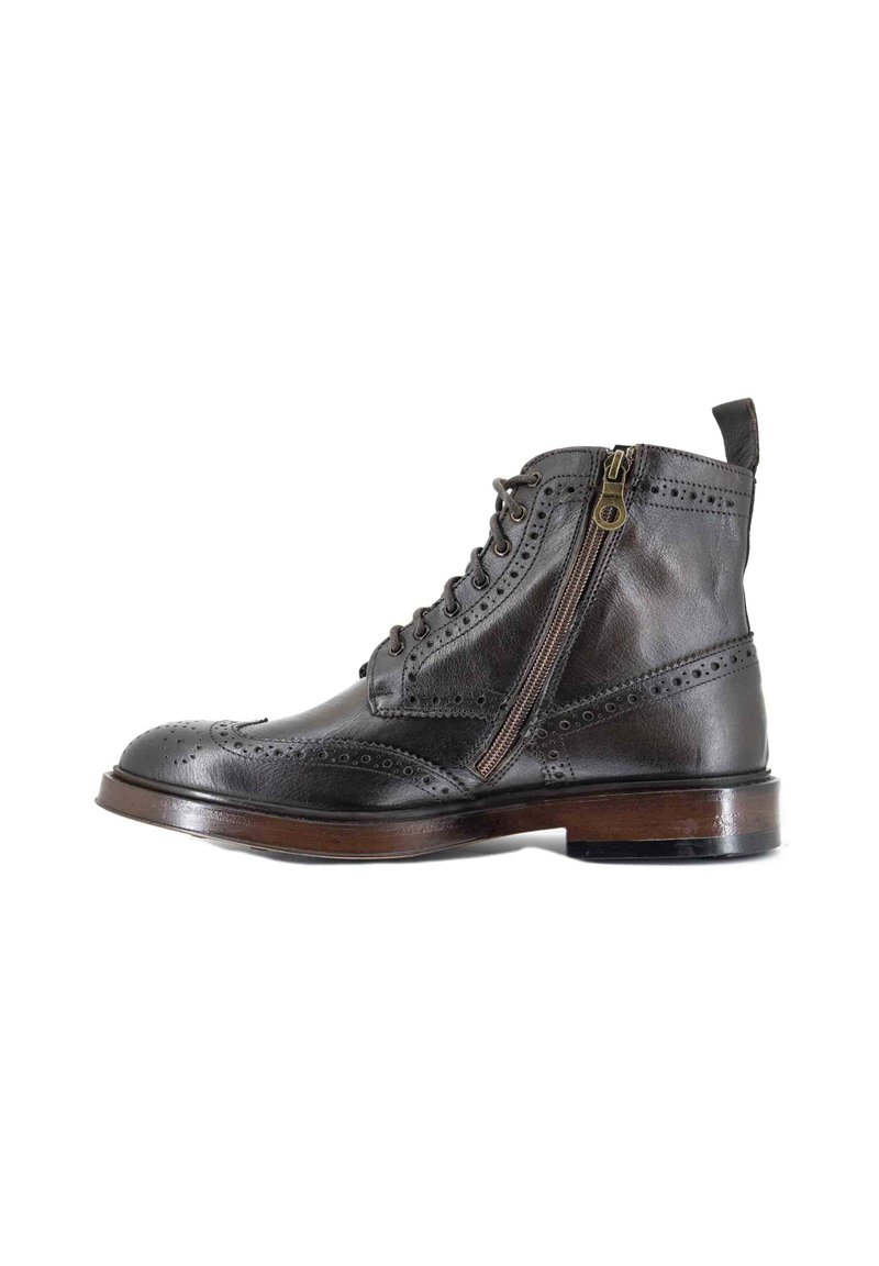 Gli stivali alla caviglia in pelle nera presentano dettagli brogue, una cerniera laterale e un tacco in legno marrone. Il design è strutturato con una finitura liscia.